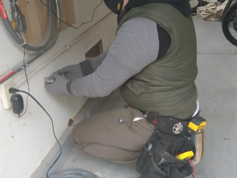 Electrician performing outlet wiring in a Seguin garage